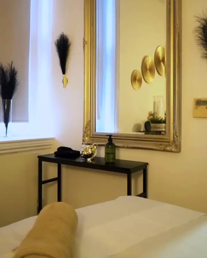 Calm treatment room with a gilt mirror at ZARA Aesthetic Medical Clinic