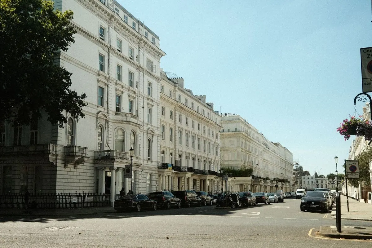 A long white stucco terrace on a quiet residential London street